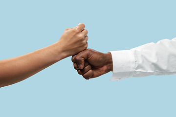 Image showing Two male hands competion in arm wrestling isolated on blue studio background