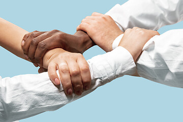 Image showing Male and female hands holding isolated on blue studio background