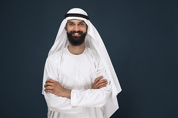 Image showing Arabian saudi businessman on dark blue studio background