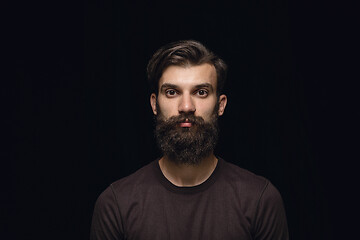 Image showing Close up portrait of young man isolated on black studio background