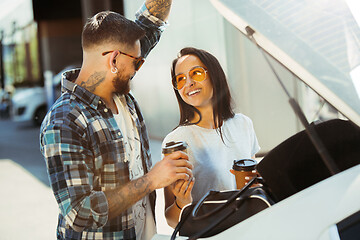 Image showing Young couple preparing for vacation trip on the car in sunny day