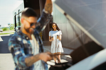 Image showing Young couple preparing for vacation trip on the car in sunny day