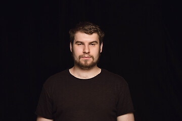 Image showing Close up portrait of young man isolated on black studio background