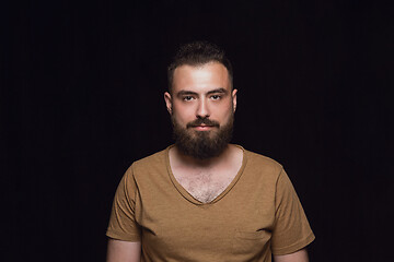 Image showing Close up portrait of young man isolated on black studio background