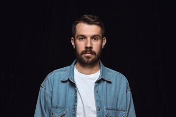 Image showing Close up portrait of young man isolated on black studio background