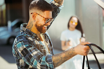 Image showing Young couple preparing for vacation trip on the car in sunny day