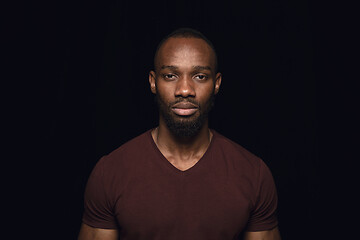 Image showing Close up portrait of young man isolated on black studio background