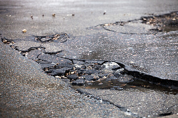 Image showing Broken pavement and pothole asphalt road after winter.