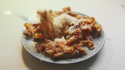 Image showing Cheese topping beiing applied to bowl of pasta