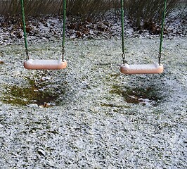 Image showing children's swing in the yard covered with the snow