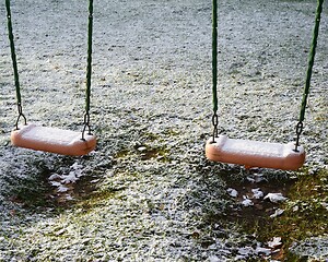 Image showing children's swing in the yard covered with the snow