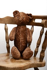 Image showing teddy bear sitting in an old vintage wooden armchair