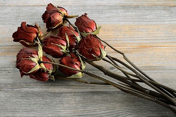 Image showing bouquet of withered roses on a wooden
