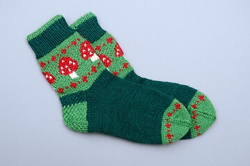 Image showing a woolen socks with amanita on neutral background 