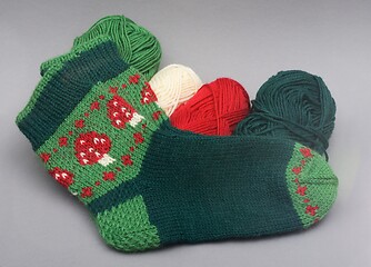 Image showing a woolen socks with amanita print and skeins of thread