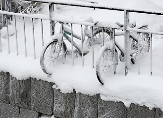 Image showing two snow covered bikes on the coast 