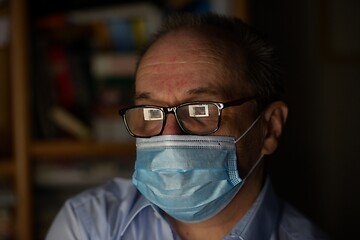 Image showing a man wearing glasses and a protective medical mask in front of 