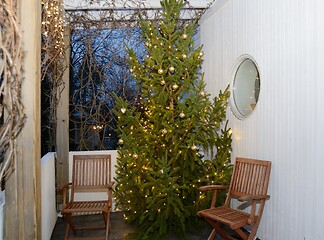 Image showing Christmas tree and two chairs on the terrace 