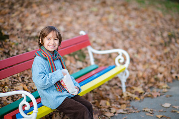 Image showing cute little boy in park eating popcorn