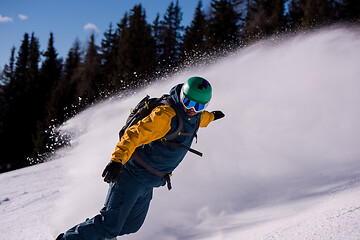 Image showing snowboarder running down the slope and ride free style