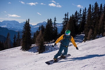 Image showing snowboarder running down the slope and ride free style