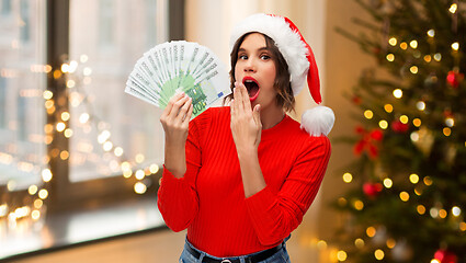 Image showing surprised woman in santa hat with money