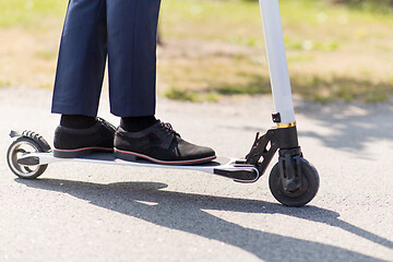 Image showing young businessman with electric scooter outdoors