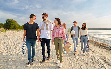 Image showing happy friends walking along summer beach