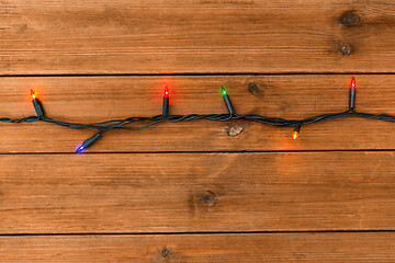 Image showing christmas garland lights on wooden background