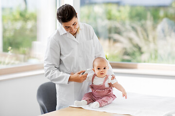 Image showing doctor with thermometer measures baby temperature