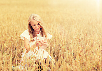 Image showing happy woman with smartphone and earphones