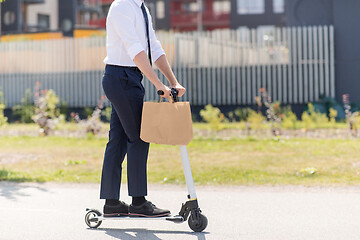 Image showing businessman with takeaway paper bag riding scooter
