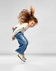 Image showing smiling little girl jumping