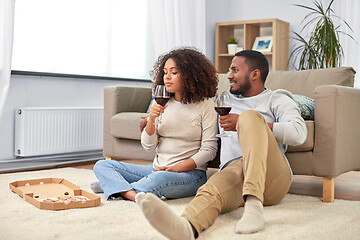 Image showing happy couple with wine and takeaway pizza at home