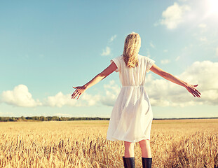 Image showing happy young woman in white dress on cereal field