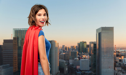 Image showing happy woman in red superhero cape over tokyo city