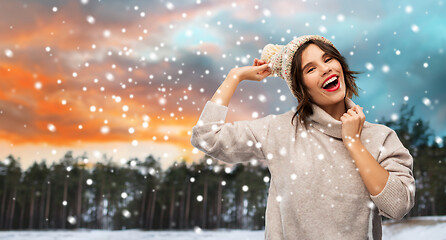 Image showing woman in hat and sweater over winter forest