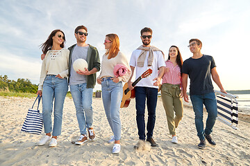 Image showing happy friends walking along summer beach