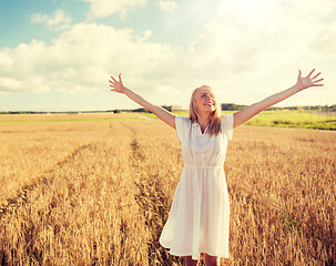 Image showing smiling young woman in white dress on cereal field