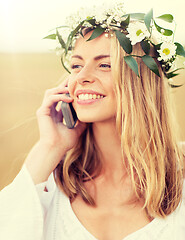Image showing happy young woman calling on smartphone at country