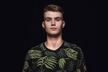 Image showing Close up portrait of young man isolated on black studio background