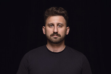 Image showing Close up portrait of young man isolated on black studio background