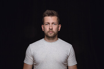 Image showing Close up portrait of young man isolated on black studio background