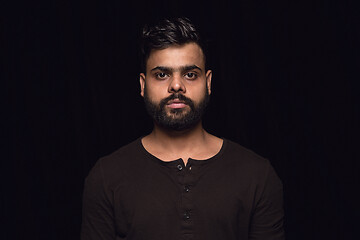 Image showing Close up portrait of young man isolated on black studio background