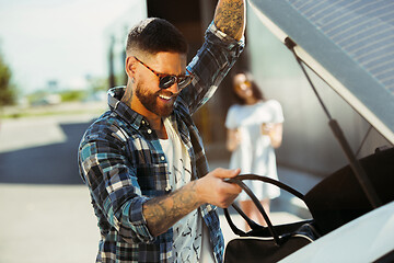 Image showing Young couple preparing for vacation trip on the car in sunny day