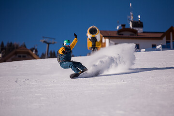 Image showing snowboarder running down the slope and ride free style