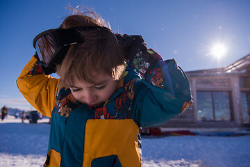 Image showing little boy having a problem with ski goggles