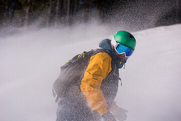 Image showing snowboarder running down the slope and ride free style