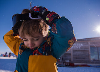 Image showing little boy having a problem with ski goggles