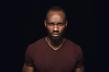 Image showing Close up portrait of young man isolated on black studio background